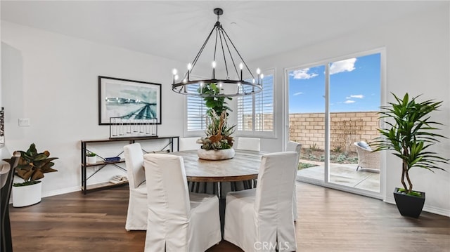 dining space featuring a chandelier, wood finished floors, and baseboards