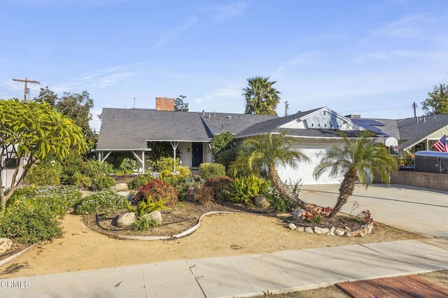 view of front of home with driveway, a chimney, and a garage
