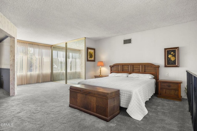 bedroom with visible vents, carpet, and a textured ceiling
