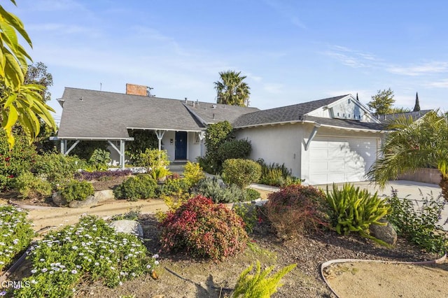 ranch-style home featuring driveway, an attached garage, and a chimney