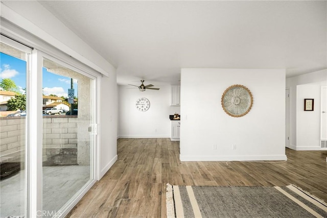 interior space with light wood-style floors, baseboards, and ceiling fan