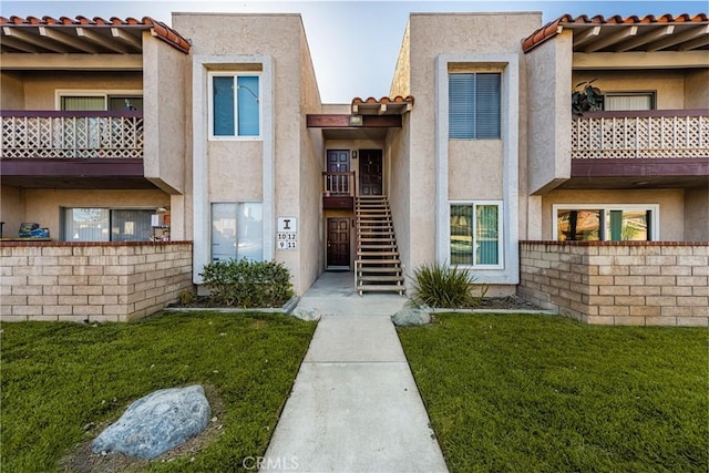 700 W La Veta Ave Unit I11, Orange, CA 92868 - property entrance with stucco siding, a tile roof, and a lawn