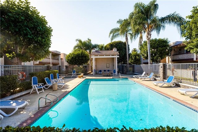 pool featuring fence and a patio area