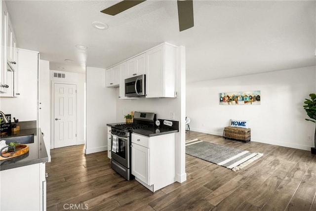 kitchen with visible vents, a sink, dark countertops, stainless steel appliances, and ceiling fan