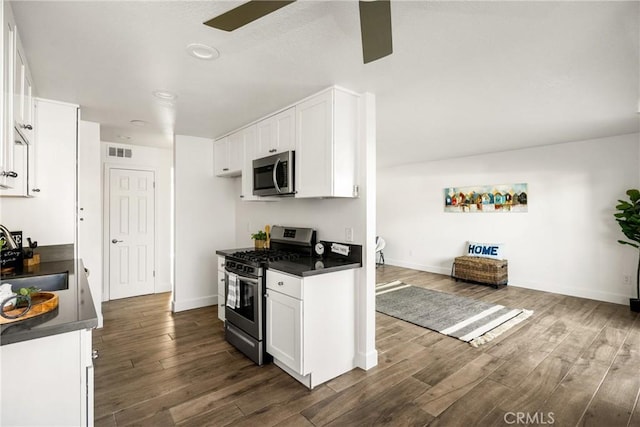 700 W La Veta Ave Unit I11, Orange, CA 92868 - kitchen featuring appliances with stainless steel finishes, dark countertops, a sink, a ceiling fan, and dark wood-type flooring