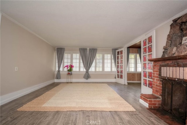 interior space featuring a brick fireplace, crown molding, plenty of natural light, and wood finished floors