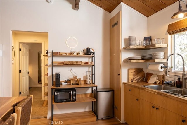 interior space with black microwave, wooden ceiling, a sink, and open shelves