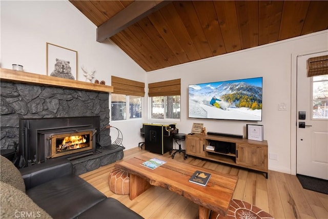 living area featuring vaulted ceiling with beams, a fireplace, wood ceiling, and light wood-style floors