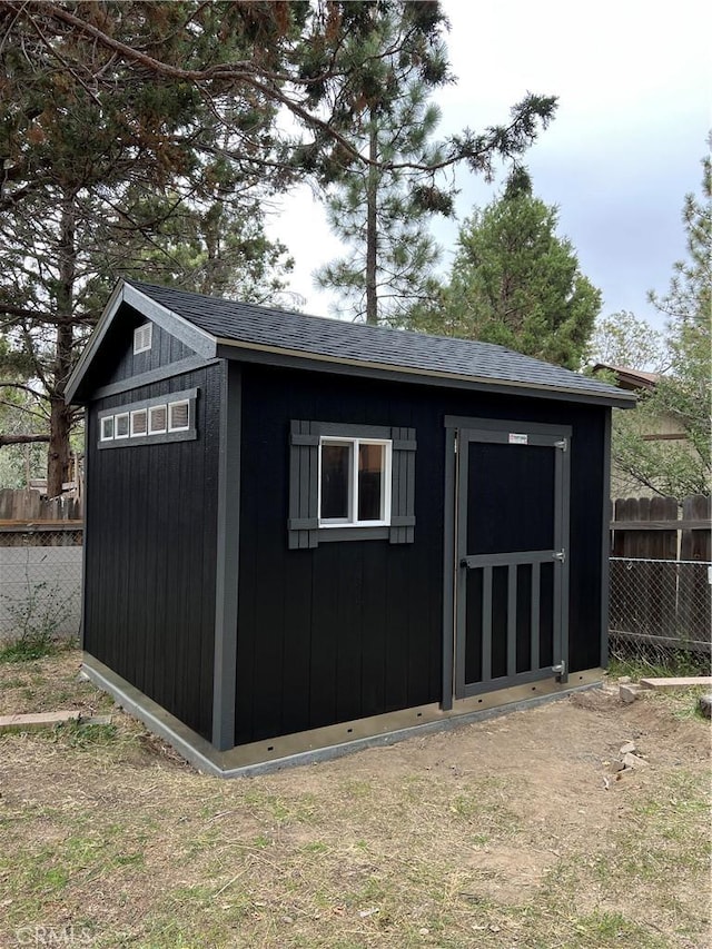 view of shed featuring fence