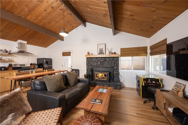 living area with lofted ceiling with beams, light wood finished floors, wood ceiling, and a fireplace