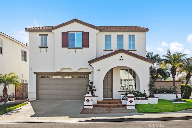 mediterranean / spanish house with concrete driveway, a tiled roof, and stucco siding