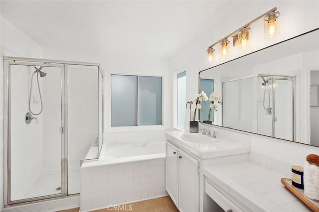 full bath featuring a garden tub, a shower stall, and vanity