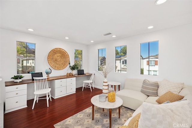 living room with built in desk, wood finished floors, and a wealth of natural light