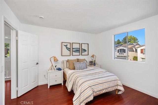 bedroom with baseboards and wood finished floors