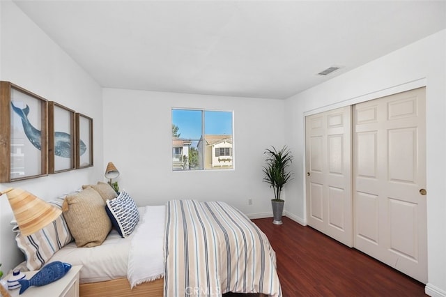 bedroom featuring a closet, baseboards, and wood finished floors