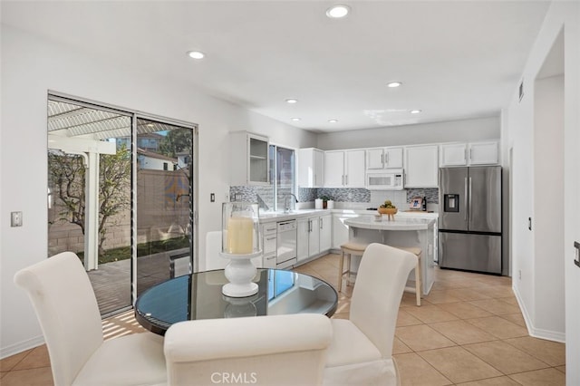 dining area featuring light tile patterned floors, baseboards, a wealth of natural light, and recessed lighting