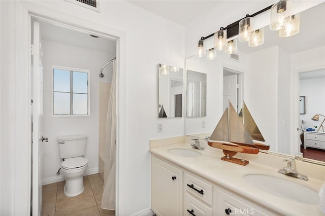 bathroom with double vanity, a sink, toilet, and tile patterned floors