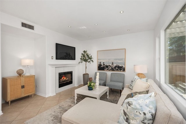 living room with light tile patterned floors, recessed lighting, visible vents, and a tile fireplace