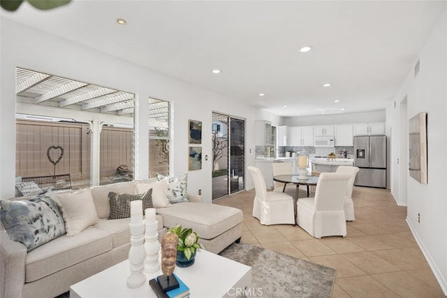 living room featuring baseboards, light tile patterned flooring, visible vents, and recessed lighting