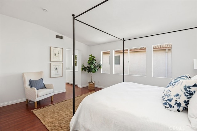 bedroom featuring lofted ceiling, wood finished floors, visible vents, and baseboards