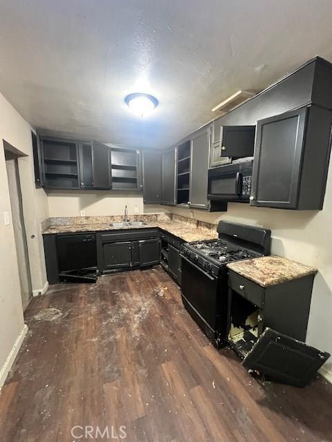 kitchen with dark wood-style flooring, dark cabinetry, black appliances, open shelves, and a sink