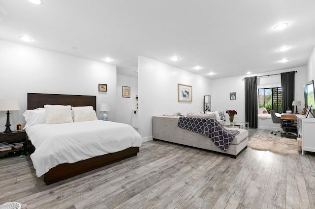 bedroom featuring baseboards, wood finished floors, and recessed lighting