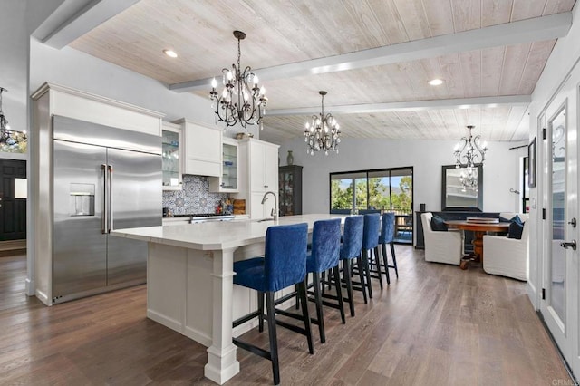 kitchen featuring decorative backsplash, wooden ceiling, stainless steel built in fridge, and a chandelier