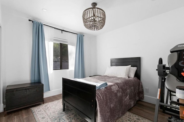 bedroom featuring baseboards, a chandelier, and wood finished floors