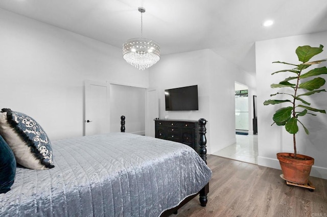 bedroom with recessed lighting, wood finished floors, ensuite bath, baseboards, and a chandelier