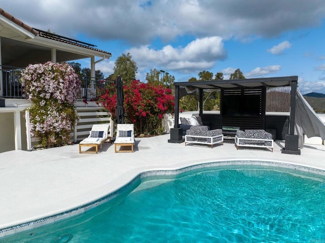 pool with an outdoor living space, a patio, and stairs