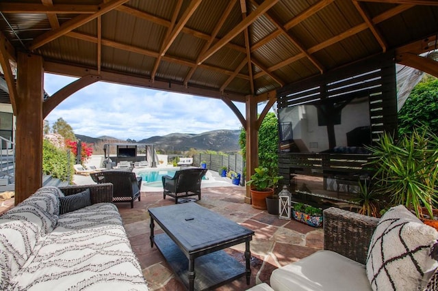 view of patio / terrace featuring a fenced in pool, fence, an outdoor hangout area, a gazebo, and a mountain view