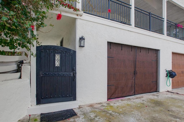 doorway to property featuring stucco siding and a garage