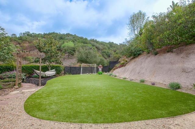 view of yard featuring fence and a pergola