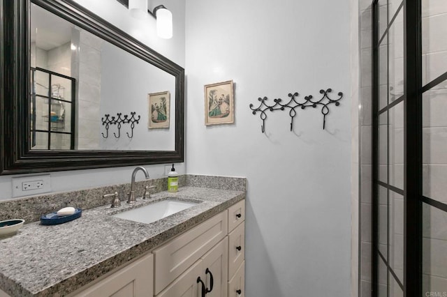 full bath featuring vanity and tiled shower