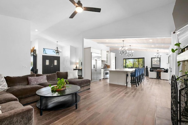living room with ceiling fan with notable chandelier, vaulted ceiling, recessed lighting, and light wood-style flooring