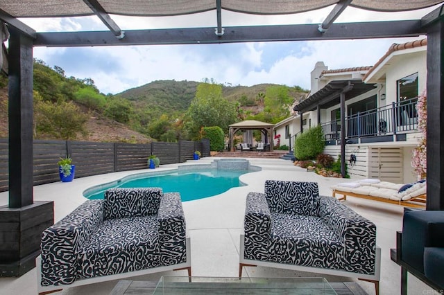 view of swimming pool with a fenced in pool, a mountain view, a gazebo, outdoor lounge area, and a patio