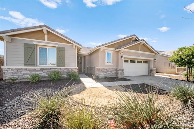 craftsman house with a garage, stone siding, concrete driveway, and a tiled roof