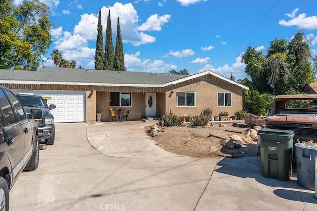 ranch-style house with driveway, an attached garage, and stucco siding