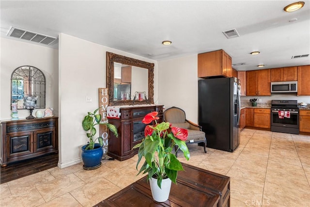 kitchen featuring brown cabinets, visible vents, and stainless steel appliances