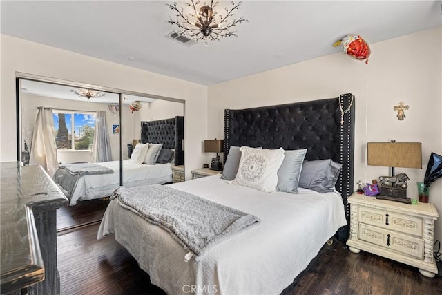 bedroom with a closet, wood finished floors, and visible vents