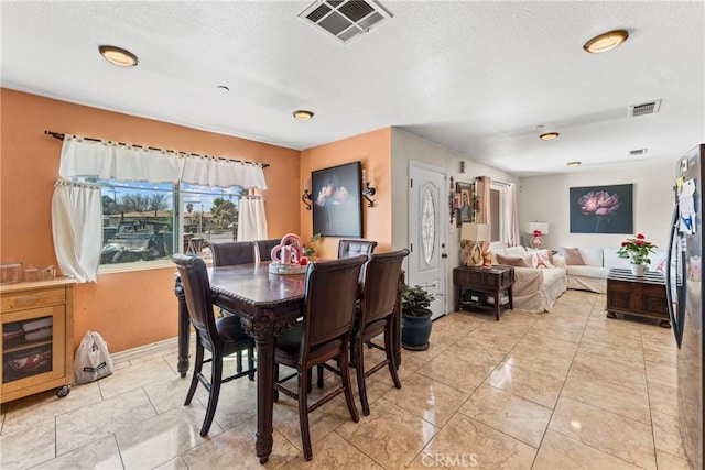 dining room with a textured ceiling and visible vents