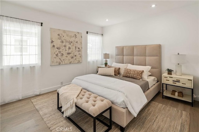 bedroom featuring baseboards, wood finished floors, and recessed lighting