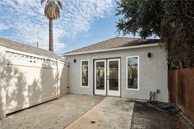 rear view of house featuring a patio area, fence, and stucco siding