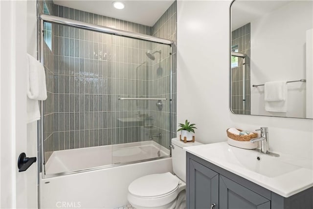 bathroom with enclosed tub / shower combo, vanity, and toilet