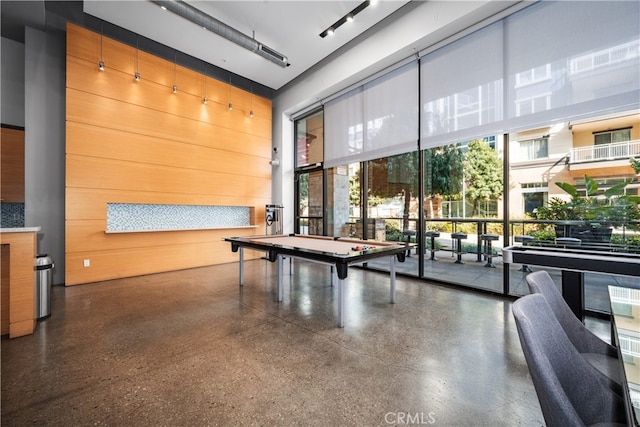 rec room with pool table, wood walls, and a towering ceiling