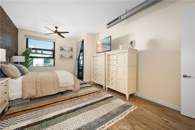 bedroom featuring a ceiling fan, baseboards, and wood finished floors