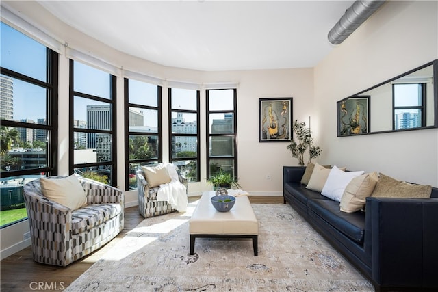 living area featuring a view of city, baseboards, and wood finished floors