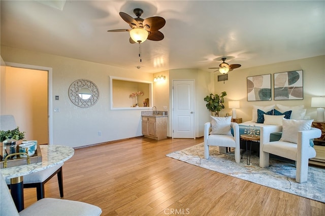 living room with light wood finished floors and ceiling fan