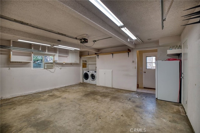 garage with separate washer and dryer, cooling unit, and freestanding refrigerator