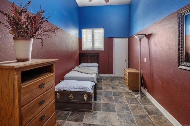 bedroom featuring stone finish flooring and baseboards